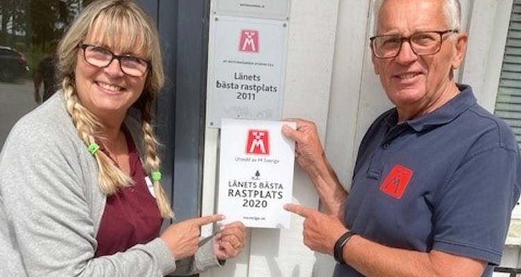 2020: Vägombud Sven Milered och Susanne Pettersson, ansvarig köpman på Herrbeta som sätter upp skylten "Länets bästa rastplats"