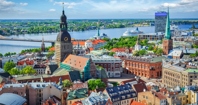 Den breda Daugavafloden flyter genom huvudstaden Riga.