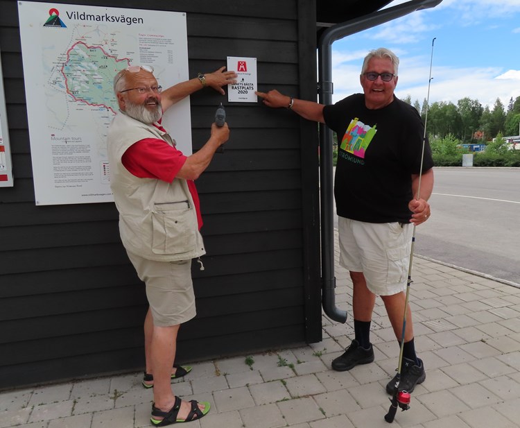 På bilden ses vägombud Stig-Björn Sundell som sätter upp skylten "Länets Bästa Rastplats 2020" tillsammans med före detta kommunalråd i Strömsunds kommun Göran Bergström